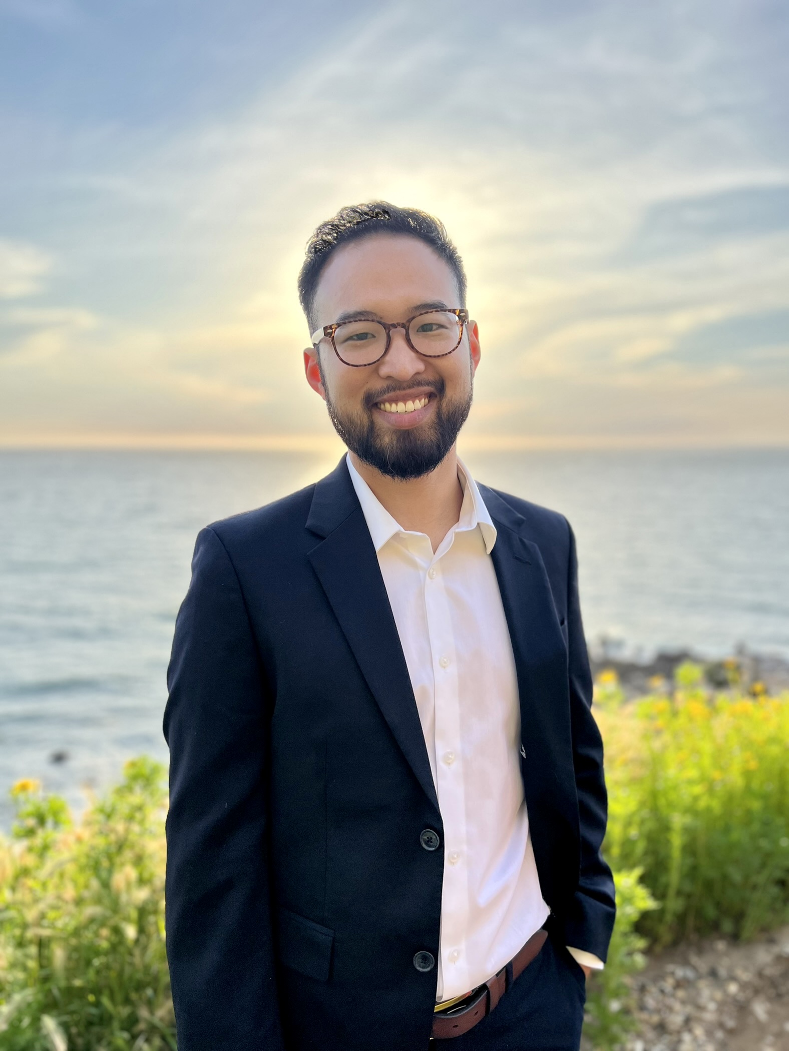 Dr. Jason Liu smiling outdoors beside the ocean
